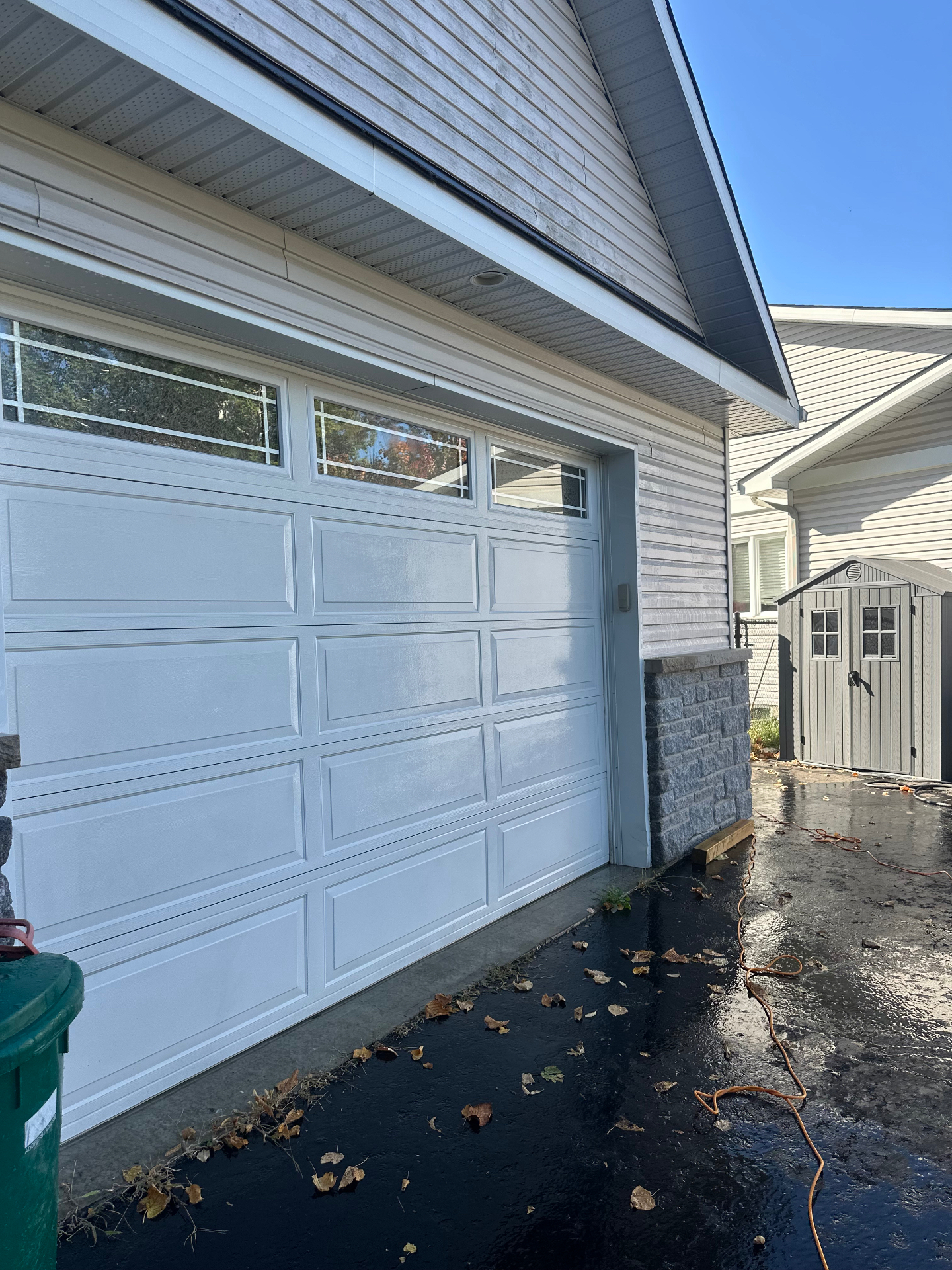 Freshly pressure washed driveway and clean white garage door